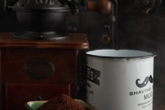Vintage coffee grinder, coffer and coffee cup over wood in a dark enviroment